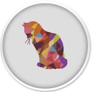 Puede incluir: Un patrón de punto de cruz con la silueta de un gato geométrico de colores. El gato está sentado y mirando hacia la izquierda. Los colores son una mezcla de rosa, morado, naranja, amarillo, verde y azul.