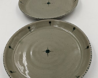 Par de platos llanos hechos a mano, esmaltados en celadón verde claro con puntos verde oscuro