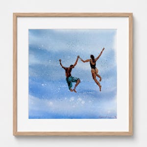 May include: A framed watercolor painting depicting two figures jumping in mid-air against a blue, splattered background. One figure wears teal shorts, and the other wears a black swimsuit. The artwork is signed in the bottom right corner.