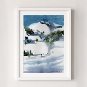 May include: A framed watercolor painting depicting a snowy mountain ski slope with dark green pine trees, small figures of skiers, and a ski lift line against a deep blue sky. The artwork features soft blue and white tones with a signature at the bottom.
