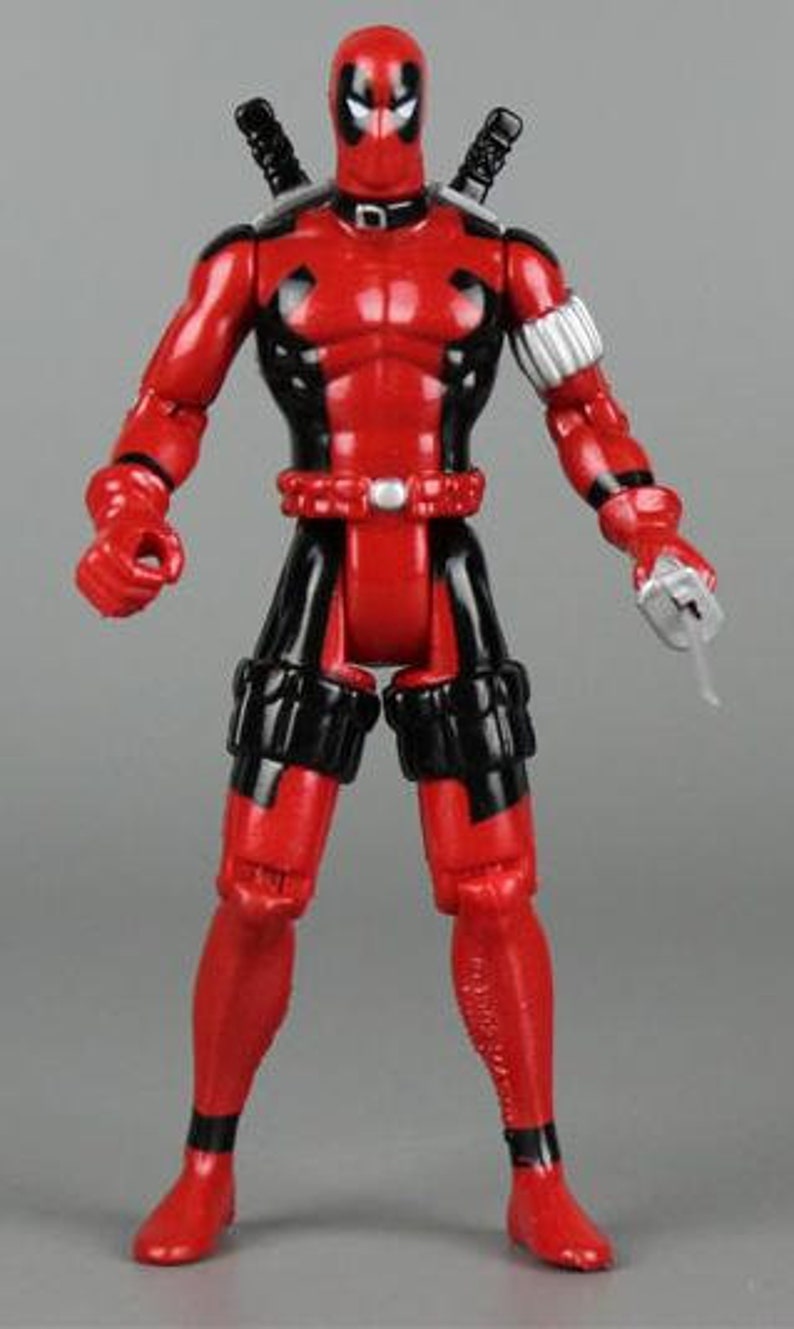 May include: A red and black action figure of Deadpool, a superhero with a mask, holding a silver sword. The figure has a black belt and black leg straps.