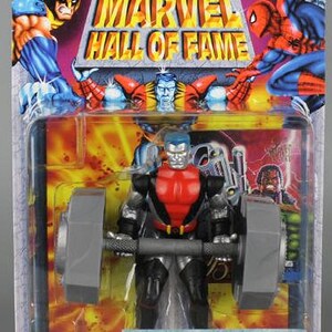 May include: A red and silver action figure of Colossus from Marvel Comics. The figure is holding a large barbell weight. The figure is posed in a lifting position. The packaging features the Marvel Hall of Fame logo.