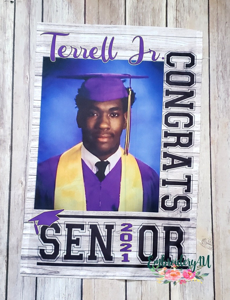 May include: A graduation banner with a photo of a graduate wearing a purple cap and gown. The banner says "Terrell Jr. Congrats Senior 2021" in black and white text with a purple graduation cap graphic.