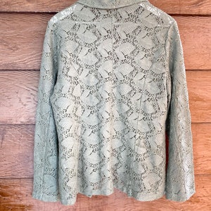 May include: A sage green lace blazer with a collar and long sleeves.