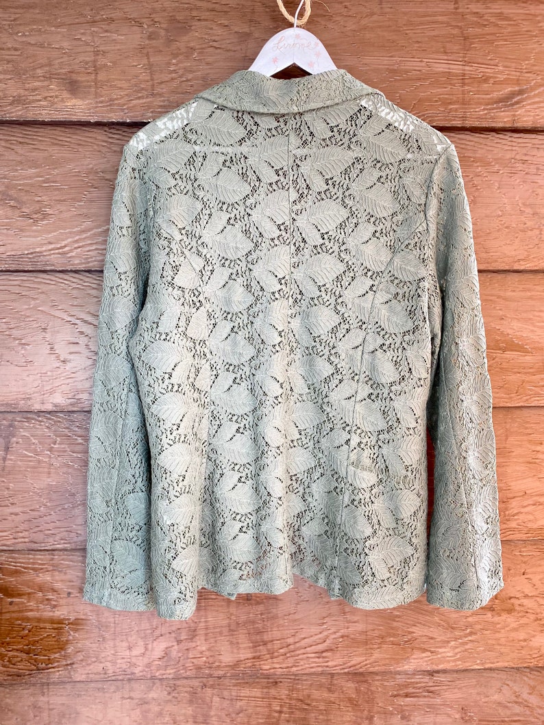 May include: A sage green lace blazer with a collar and long sleeves.