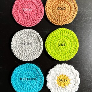 May include: Six crocheted coasters in various colours and designs. The coasters are labelled "Rosey", "Gold", "Silver", "Lime", "Turquoise", and "Daisy".