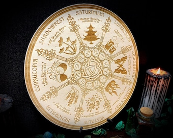 Könnte beinhalten: Ein rundes Holzrad mit einem goldfarbenen Design, das das Rad des Jahres darstellt, einen heidnischen Kalender mit acht saisonalen Festen. Das Rad ist in acht Abschnitte unterteilt, die jeweils ein anderes Fest repräsentieren. Die Feste sind mit ihren Namen und Daten beschriftet. Das Rad ist von einem dekorativen Rand umgeben.