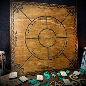 May include: A wooden board with a circular design depicting the nine realms of Norse mythology. The realms are labelled in Old Norse: Muspelheim, Asgard, Vanaheim, Jotunheim, Midgard, Niflheim, Svartalfheim, Hel, and Lightelfheim.
