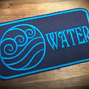 May include: Blue and black embroidered patch with a stylised water symbol and the word "WATER" in blue.