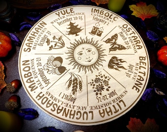 Op de afbeelding: Een houten wiel met acht secties, die elk een andere heidense feestdag vertegenwoordigen. De feestdagen zijn met de klok mee opgesomd, te beginnen met Samhain, Halloween, Yule, Imbolc, Ostara, Beltane, Litha en Lughnasadh. Elke sectie heeft een symbool dat de feestdag vertegenwoordigt, zoals een pompoen voor Samhain, een boom voor Yule en een vlinder voor Ostara.