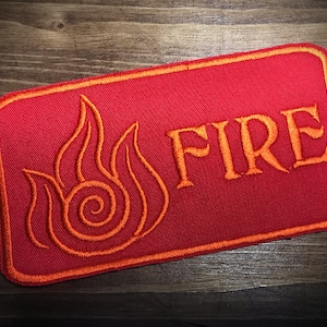 May include: Red embroidered patch with an orange flame symbol and the word "FIRE" in orange lettering.