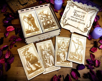 May include: A wooden box containing a set of tarot cards with illustrations of the Major Arcana. The box is engraved with the text "Oswald Wirth Tarot 1889 original design 22 MAJOR ARCANA".
