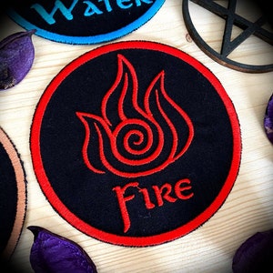 May include: A black and red embroidered patch featuring a stylised flame design and the word "Fire" in red lettering.
