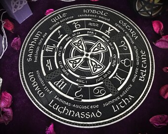 Könnte beinhalten: Ein schwarzes Holzrad mit silbernen Beschriftungen und einem keltischen Knotendesign. Das Rad ist in acht Abschnitte unterteilt, die jeweils eine andere Jahreszeit im keltischen Kalender repräsentieren. Die Namen der Feste sind in silbernen Buchstaben um das Rad herum geschrieben. Das Rad ist von einem violetten Hintergrund umgeben.