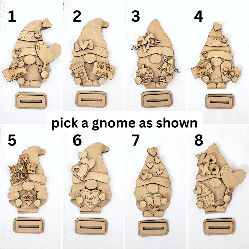 Puede incluir: Ocho adornos de gnomo de madera sin terminar con diferentes dise&ntilde;os tem&aacute;ticos de San Valent&iacute;n. Los gnomos sostienen corazones, letreros y otras decoraciones. Los gnomos est&aacute;n numerados del 1 al 8.