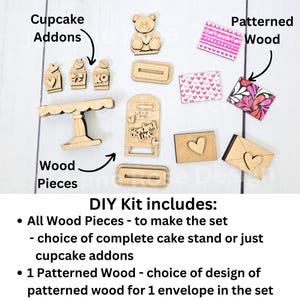 Pode incluir: Kit de bricolage para fazer um suporte para cupcakes e envelopes com tema de Dia dos Namorados. O kit inclui pe&ccedil;as de madeira para o suporte, os cupcakes e os envelopes, bem como madeira estampada para um envelope. O kit tamb&eacute;m inclui um pequeno urso de madeira.