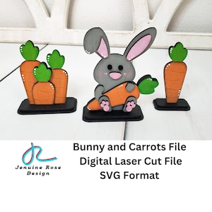 Könnte beinhalten: Eine digitale Laserschneidedatei für einen grauen Hasen, der eine Karotte hält, und drei Karotten mit grünen Blättern. Die Datei ist im SVG-Format. Bunny and Carrots File Digital Laser Cut File SVG Format