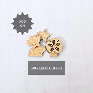 Può includere: Un set di forme in legno tagliate al laser color marrone chiaro che raffigurano una conchiglia, una stella marina e un sand dollar. Un'icona a stella grigio scuro contiene il testo ADD ON e un riquadro grigio scuro riporta SVG Laser Cut File.
