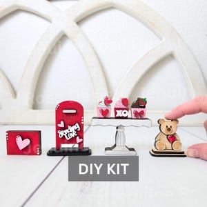 Pode incluir: Kit de artesanato para o Dia dos Namorados com uma caixa de correio vermelha, um suporte para cupcakes com tr&ecirc;s cupcakes, um urso de peluche e um pequeno envelope vermelho. A caixa de correio diz "Sending Love" e os cupcakes t&ecirc;m cora&ccedil;&otilde;es e "XO" neles.