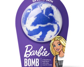 May include: A purple package featuring a Barbie-themed bath bomb. The bath bomb is a white and blue sphere. The package includes the text "DA BOMB BATH", "Barbie BOMB" and "Net Wt. 184 g."