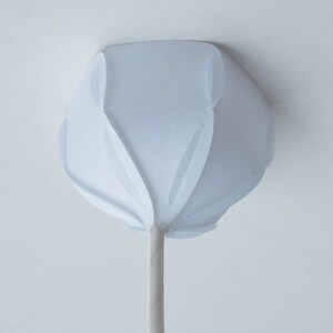 May include: White ceiling light fixture with a unique, folded paper design. The fixture has a white cord.