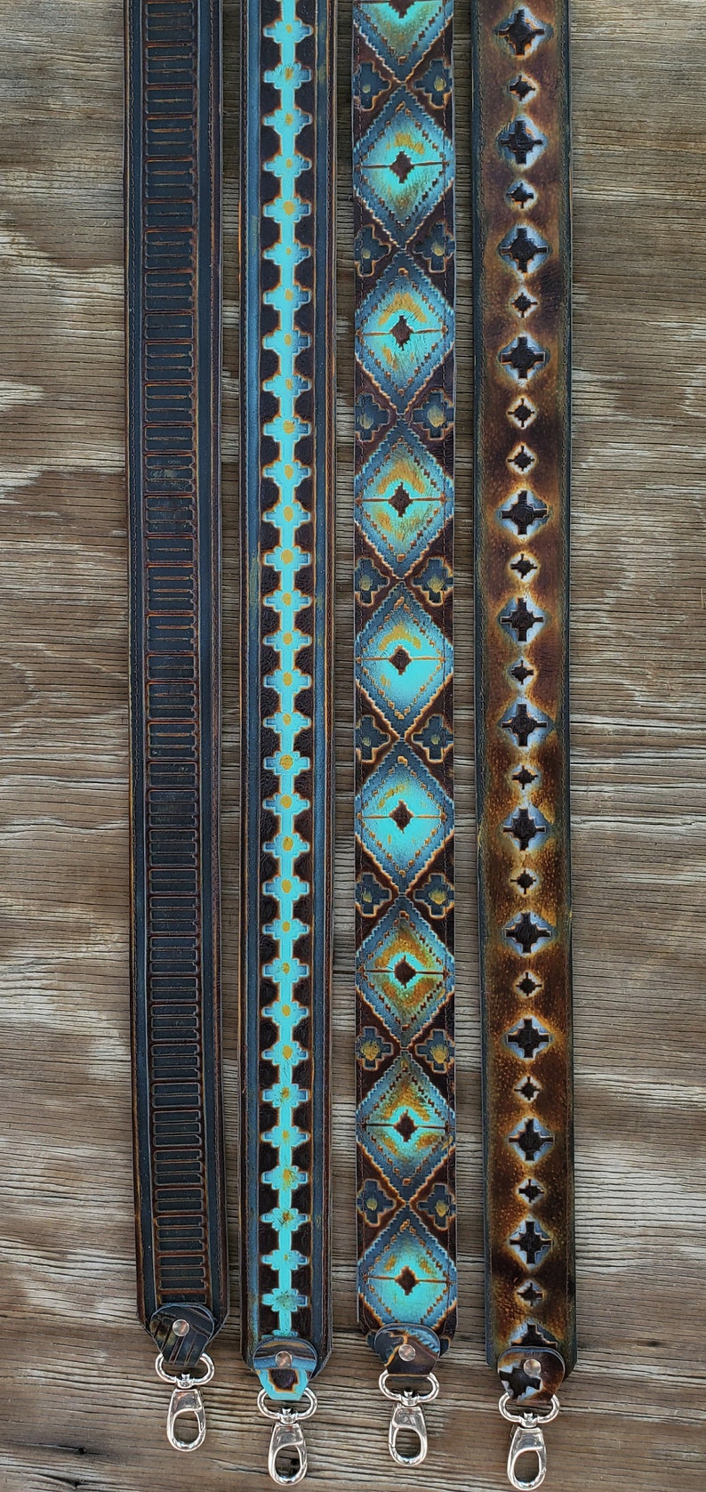 May include: Four leather straps with decorative designs and silver-coloured clasps. The straps feature embossed patterns and turquoise, brown, and black colour schemes. The straps are displayed on a wooden surface.