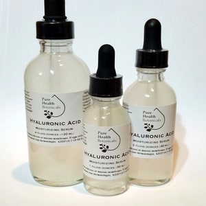 May include: Three glass bottles with dropper tops containing Hyaluronic Acid Moisturizing Serum. The bottles are labeled with the brand name "Pure Health Botanicals" and the size of the serum in fluid ounces. The bottles are on a white surface.