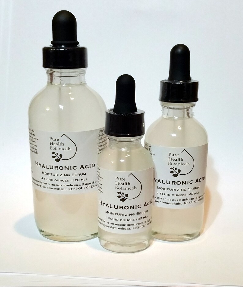 May include: Three glass bottles with dropper tops containing Hyaluronic Acid Moisturizing Serum. The bottles are labeled with the brand name "Pure Health Botanicals" and the size of the serum in fluid ounces. The bottles are on a white surface.