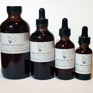 May include: Four amber glass bottles of varying sizes, each with a black dropper and a white label. The labels read "Deer Antler Velvet" and "Pure Health Botanicals". The bottles contain a dark liquid.
