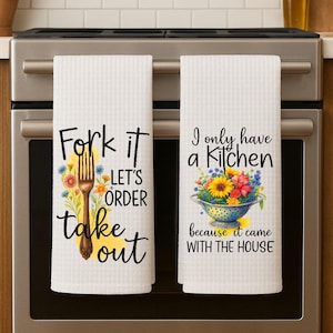 May include: Two white kitchen towels with black text and floral designs. One towel reads "Fork it, Let's Order Take Out" with a fork illustration. The other says "I only have a Kitchen because it came with the house."