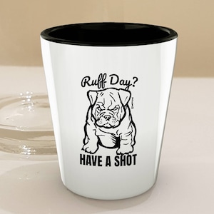 May include: White shot glass with a black rim. The glass features a black and white illustration of a bulldog with the text "Ruff Day?" and "HAVE A SHOT".