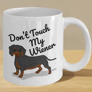 May include: White ceramic coffee mug with a black dachshund illustration and the text "Don't Touch My Wiener".
