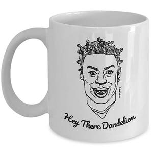 May include: White ceramic mug with a black line drawing of a person with a unique hairstyle. The text "Hey There Dandelion" is printed on the mug.