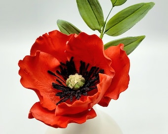 Sugar flower, handmade sugar-paste poppy with leaves. Remembrance day.