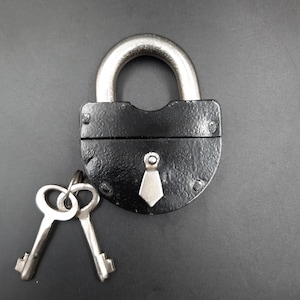 May include: A black padlock with a silver keyhole and two silver keys. The padlock has a silver tie-shaped design on the front.