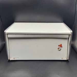 May include: White metal bread box with a red and white mushroom design.