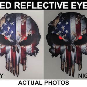 May include: A skull-shaped graphic with red reflective eyes, designed with the American flag. The design is split down the middle, with the left side showing the design in daylight and the right side at night. The text "RED REFLECTIVE EYES" and "ACTUAL PHOTOS" are displayed.