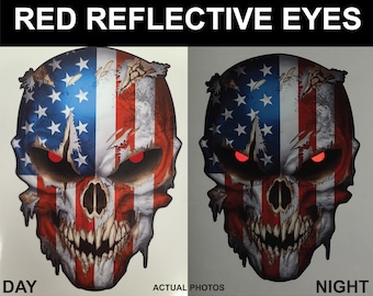 May include: A skull sticker with a distressed American flag design. The skull has red reflective eyes that glow in the dark. The sticker is shown in both day and night conditions.