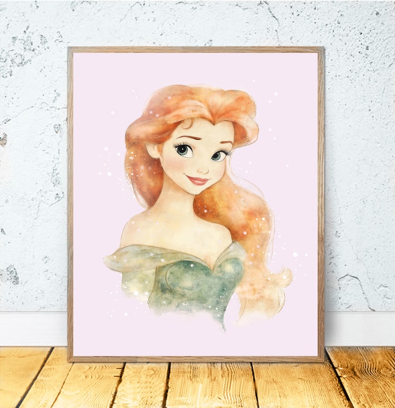 May include: A framed watercolor print of a princess with long, flowing red hair and a green off-the-shoulder dress. The artwork has a soft, dreamy quality, with a light pink background and subtle sparkle effects. The frame is a light brown color.