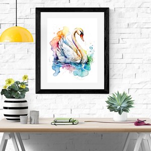 Puede incluir: Una pintura de acuarela enmarcada de un cisne blanco nadando en una escena de agua abstracta y colorida. El cisne est&aacute; mirando hacia la izquierda y tiene la cabeza girada hacia la derecha. El agua est&aacute; pintada en tonos de azul, verde, rosa y morado.