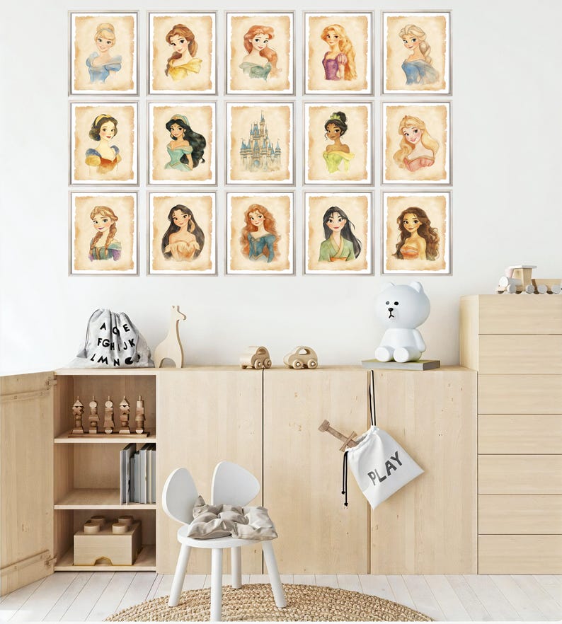 May include: A set of 15 framed prints featuring Disney princesses and the iconic Cinderella's castle. The prints are in a watercolor style and have a vintage aesthetic. The prints are arranged in a grid pattern on a white wall.