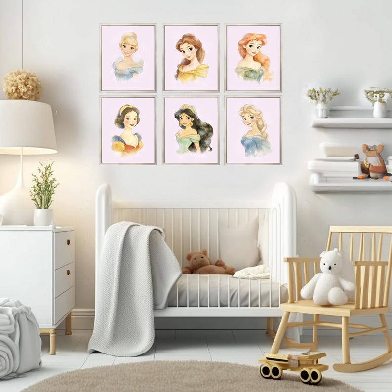 May include: Six framed watercolor portraits of princesses with various hairstyles and gowns. The portraits are displayed on a white wall above a white crib and a wooden rocking chair. The room is decorated in a soft, pastel color scheme.