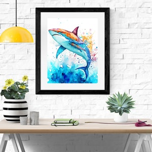 Puede incluir: Una pintura de acuarela de un tibur&oacute;n colorido saltando fuera del agua. El tibur&oacute;n est&aacute; pintado en tonos de azul, naranja y rojo, y el agua est&aacute; pintada en tonos de azul y verde. La pintura est&aacute; enmarcada en un marco negro.