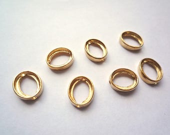 May include: Seven gold oval-shaped metal rings. The rings are smooth and have a shiny finish.