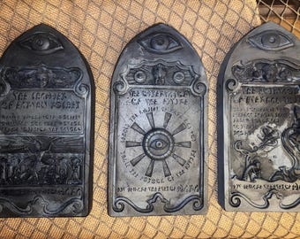 May include: Three black, rectangular, decorative plaques with an eye motif and gothic-style lettering. The plaques feature the text "The Keeper of Eternal Secrets", "The Observation of the Future", and "The Journey of Eternal Youth".