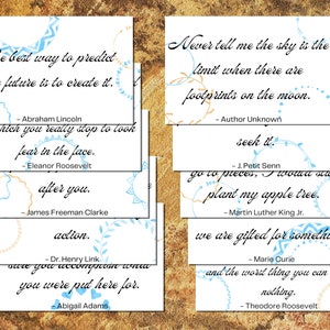 May include: A collection of white cards with inspirational quotes in black script, accented with blue and gold decorative elements. Quotes include Abraham Lincoln, Eleanor Roosevelt, and Martin Luther King Jr. The cards are arranged on a textured, golden-brown surface.