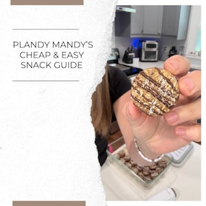 May include: A close-up of a round, brown and white snack with chocolate drizzle and coconut flakes. The snack is being held by a person's hand. The text "Plandy Mandy's Cheap & Easy Snack Guide" is visible in the background.