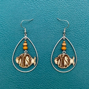 May include: A pair of silver teardrop-shaped earrings with wooden beads and a wooden fish charm with the word "FISH" engraved on it.