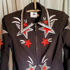 On the Rail black zip up lined black jacket adorned with red and silver sequins and rhinestones in excellent condition.  Size S.  18" P to P
