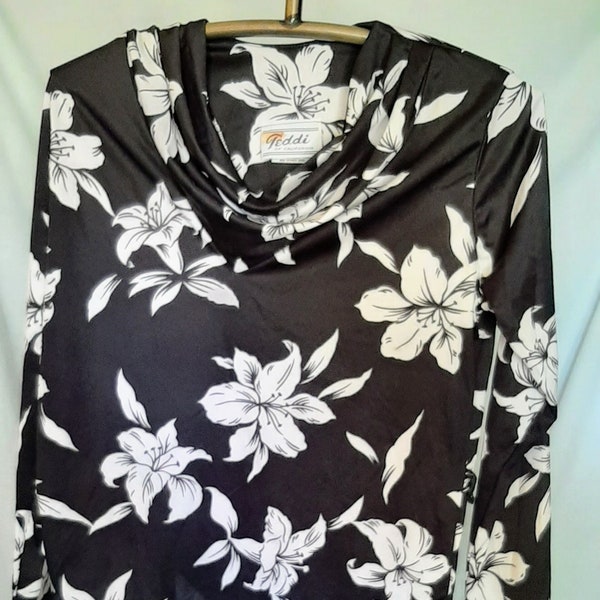 Teddi of California black long sleeved top embellished with white flowers.  Has cowl neck, missing belt in excellent condition, says size 12